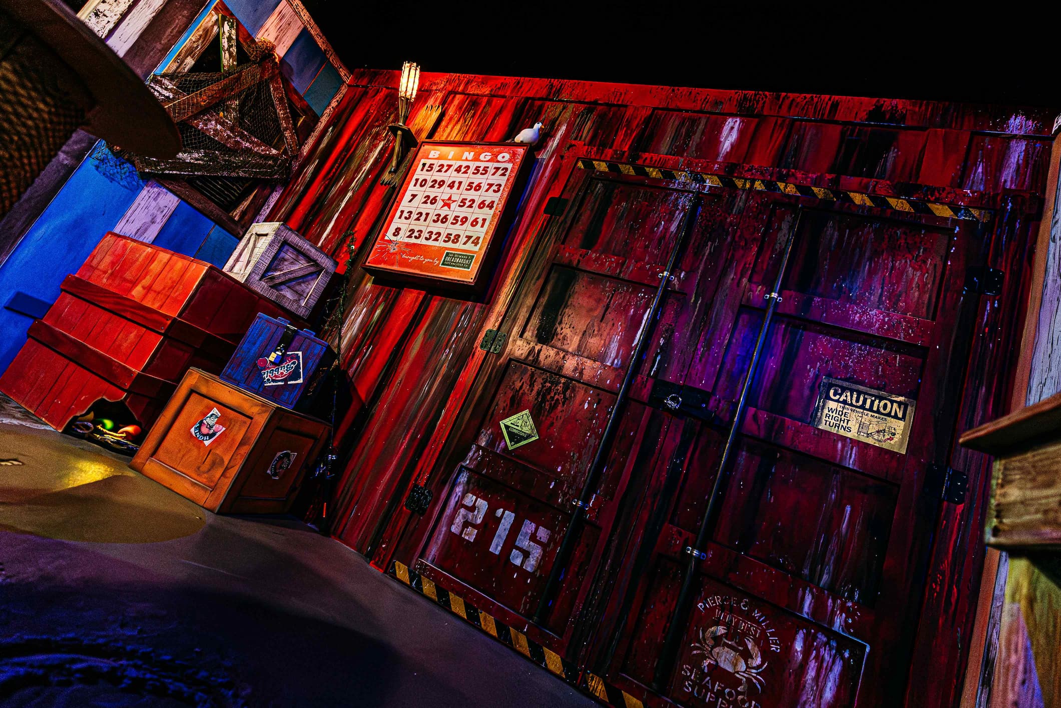 A dimly lit scene of a rustic wooden door marked with "CAUTION" and "SEAFOOD SUPP" next to a bingo board with numbers.