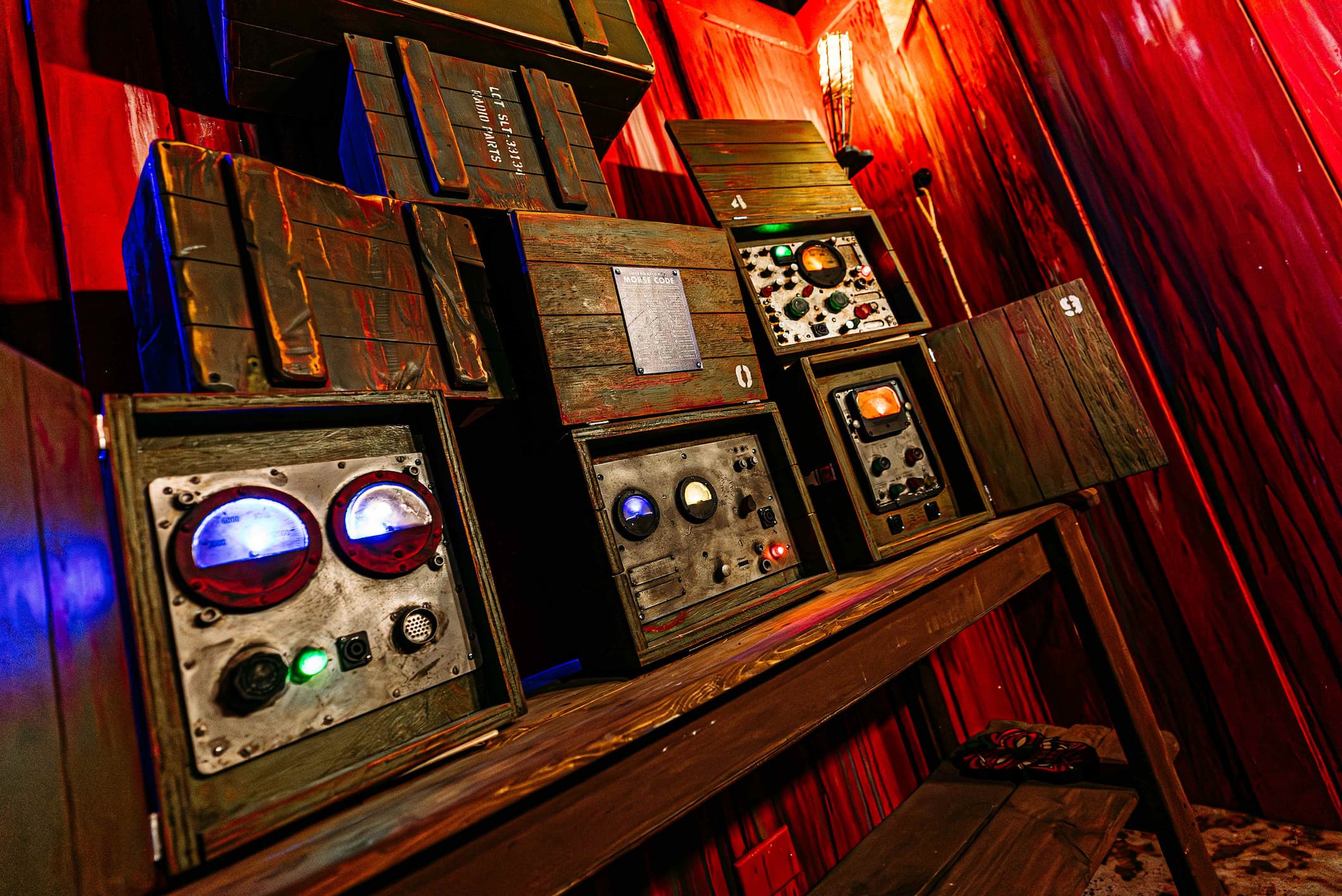 A wooden shelf holds several vintage wooden boxes with dials, gauges, and lights, possibly electrical components.